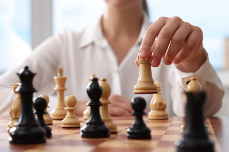 Woman playing chess during tournament at chessboard