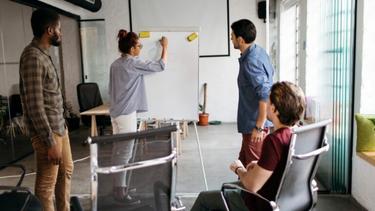 Business members using a whiteboard