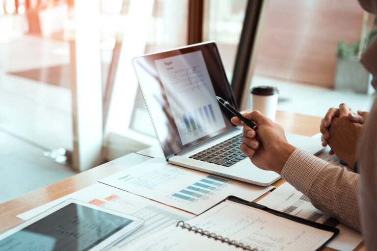 Manager is using a laptop computer while analyzing the company's financial statements